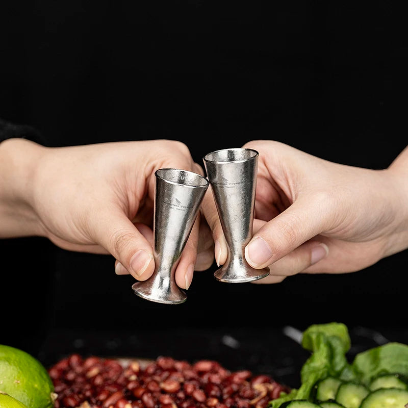 pouring-whiskey-into-titanium-shot-glass-at-home-bar
